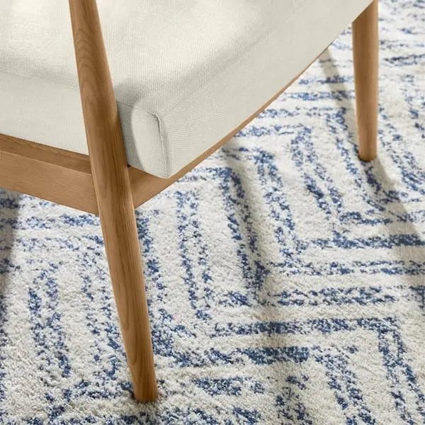 Sillón tapizado en tela color marfil con cojines removibles